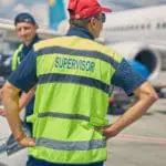 Airport Worker Standing Next To His Colleague