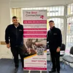 Employees of the Tamworth branch stood with new driving desk roller banner to promote new services.