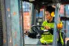 Female Worker Driving Forklift In Industrial Container Warehouse.