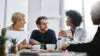 Give Us Difficult And Well Show You Easy. Shot Of A Group Of Businesspeople Sitting Together In A Meeting.