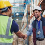 Men, Shaking Hands And Warehouse For Deal With Logistics, Smile And Contract For Global Shipping Company. People, Handshake And Happy For Agreement, Collaboration And Supply Chain For Distribution