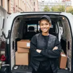 Portrait Of A Smiling Delivery Girl Wearing A Cap And Uniform St