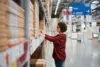 Focused Woman Selecting Furniture Panels At Large Warehouse Store