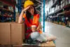 Tired Female Warehouse Worker Taking A Break And Holding A Coffee Cup