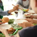 Volunteers Serving Food For Poor People Indoors