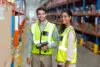 Portrait Of Smiling Warehouse Workers Scanning Box