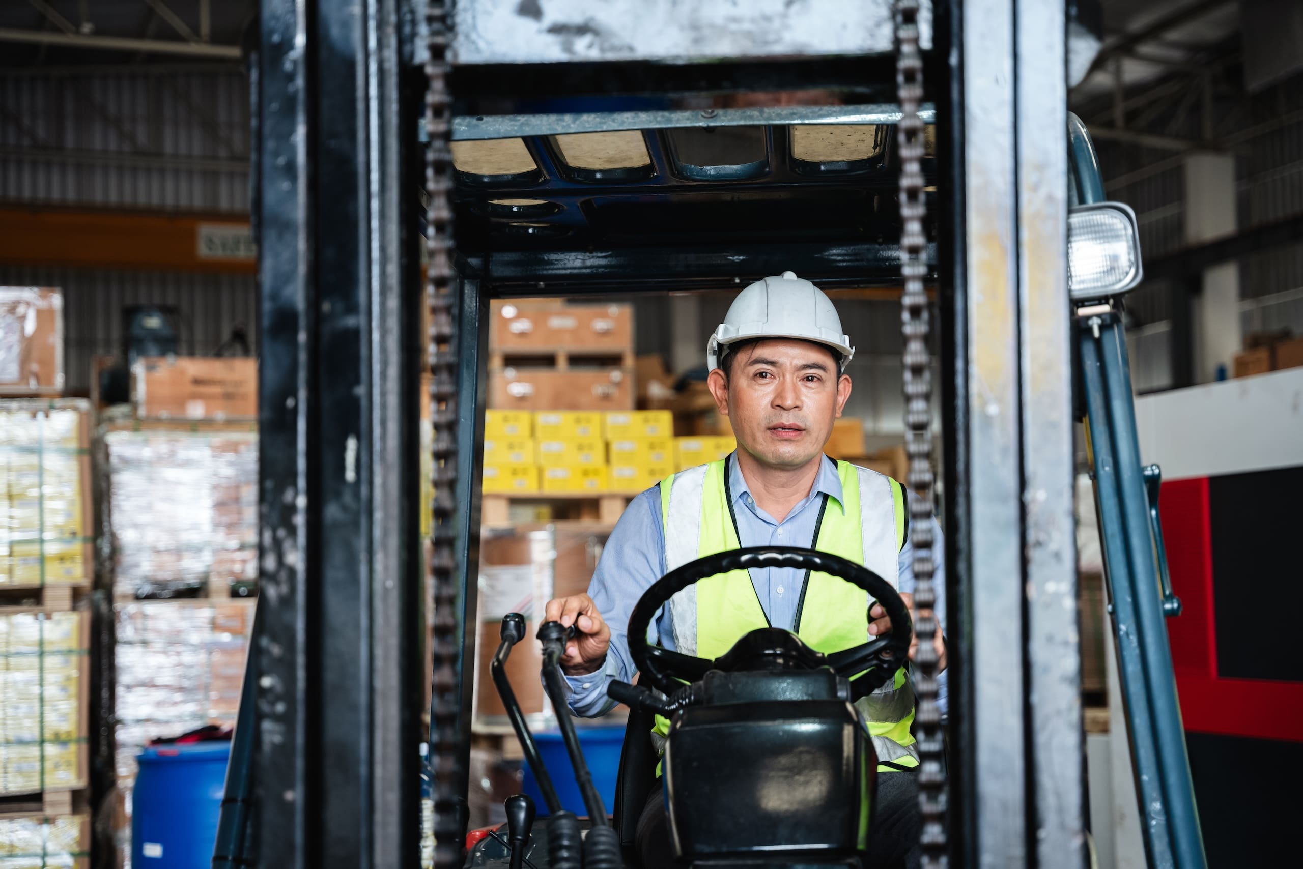 Warehouse Worker Working With A Forklift In A Warehouse Or Storehouse.