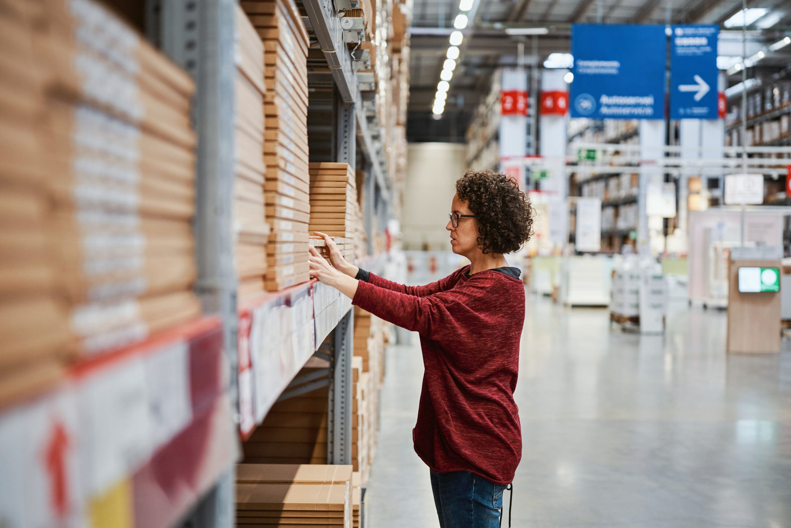 Focused Woman Selecting Furniture Panels At Large Warehouse Store