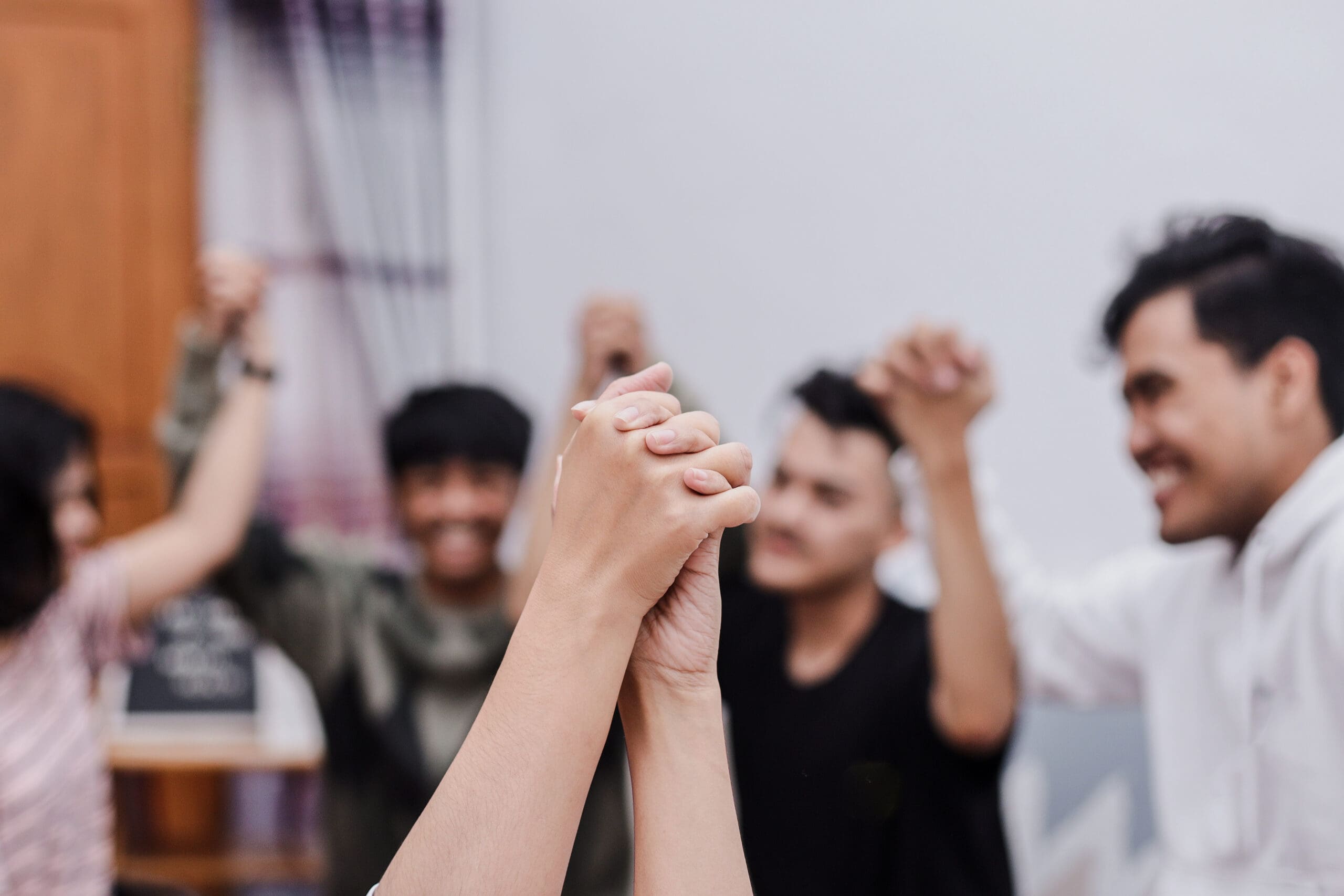 Symbolic Picture Showing That We Are Stronger Together. Two People Holding Hand And Raising In Unity.
