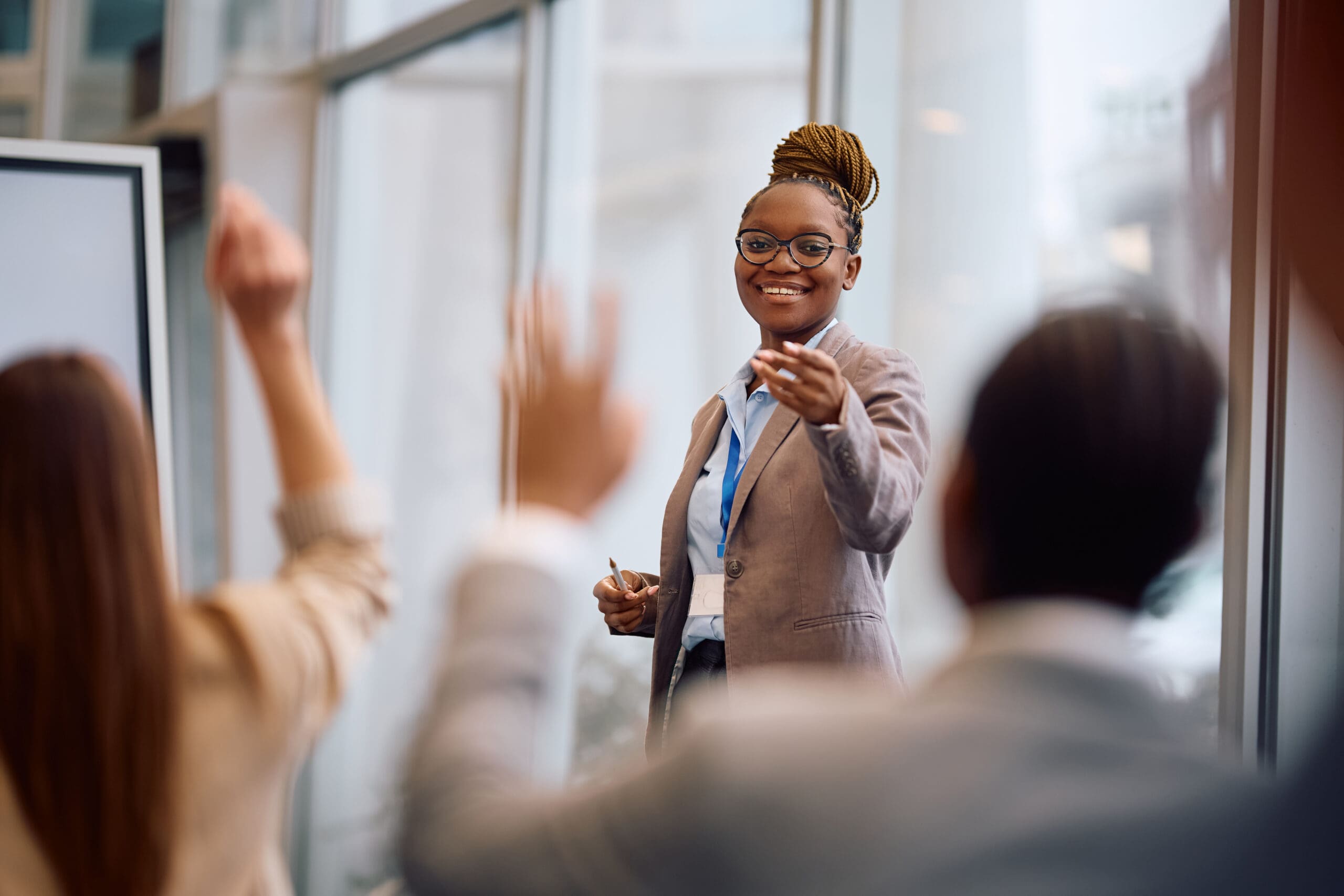 Happy Black Business Seminar Speaker Pointing At Attendee Who Wants To Ask Question In Conference Room.