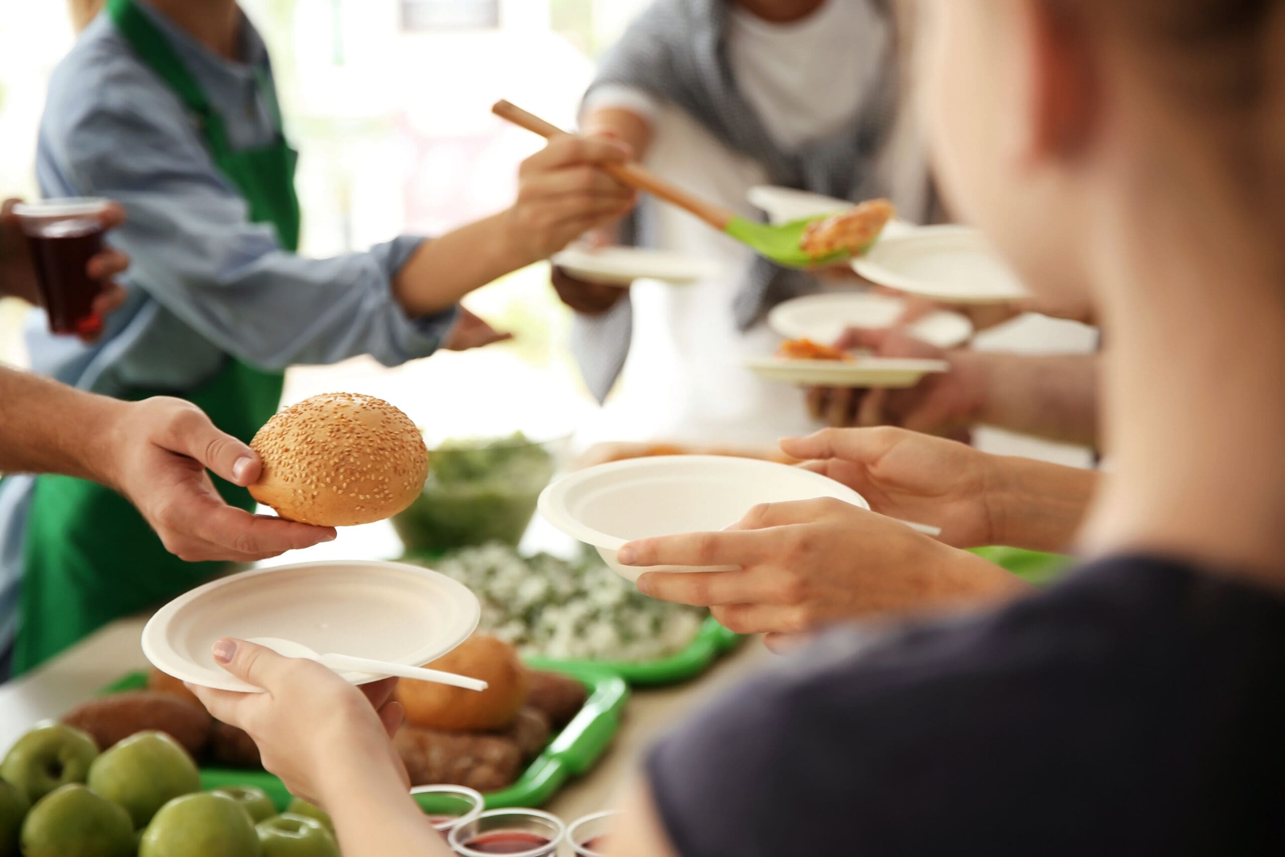 Volunteers Serving Food For Poor People Indoors